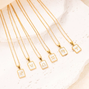 Goldene Sternzeichen-Halskette mit Perlmutt-Inlay auf weißem Stein-Hintergrund