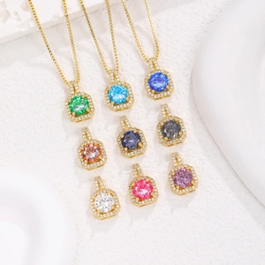 Nueve collares colgantes de circonita de colores con chapado en oro sobre fondo de piedra