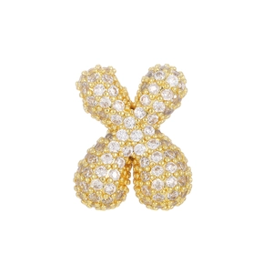 Macro shot of X-shaped gold pendant with micro-paved white zircon stones on white background