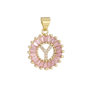 Macro shot of gold-plated pendant with letter Y and pink rectangular zircon stones