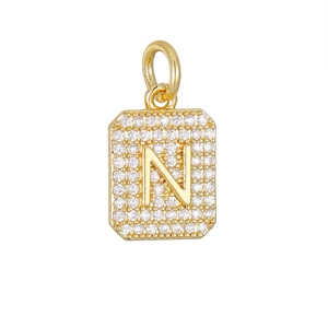 Detailopname van een gouden vierkante hanger met de letter N bezet met zirkonia steentjes