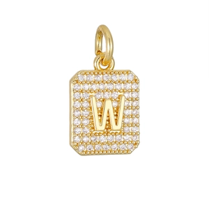 Macro-opname van gouden rechthoekige hanger met letter W en witte zirkoon versiering