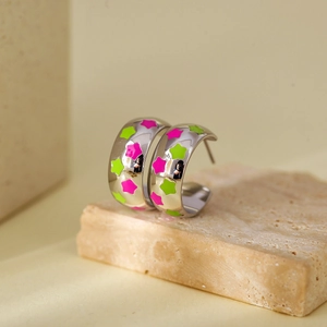 Dettaglio di orecchini a C in argento con stelle in smalto rosa e verde fluorescente