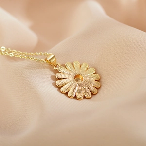 Close-up of golden sunflower pendant on silk fabric with detailed petal texture
