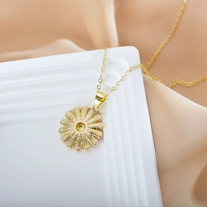 Detailed view of golden sunflower pendant with textured petals on silk fabric