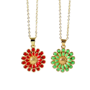 Detailed close-up of sunflower pendants in red and green enamel on gold chains