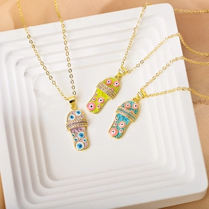 Detail of slipper pendant necklaces with blue evil eye enamel and crystal stones