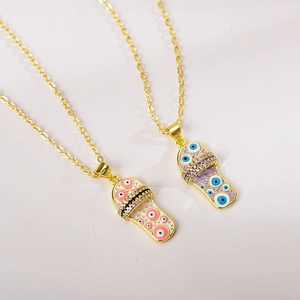 Detail of gold evil eye slipper pendants with colorful enamel and inlaid zircons