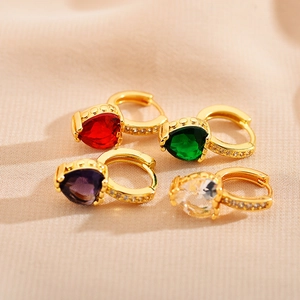 Détail macro de boucles d'oreilles en cuivre avec cristaux de cœur colorés et micro-pavage