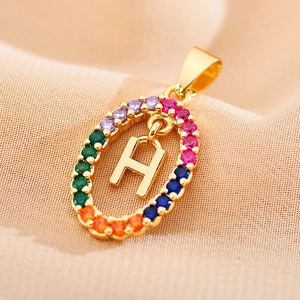 Close-up of golden letter H pendant featuring a halo of vibrant multi-colored zircons