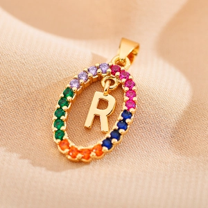 Macro shot of gold oval pendant featuring a letter R with colorful zircon pave stones