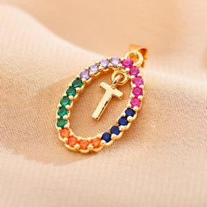 Close-up of golden oval pendant with colorful zircon stones and a mirror-finish cross