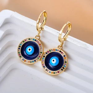Close-up van gouden Evil Eye oorbellen met blauw emaille en kleurrijke strass-steentjes