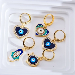Macro-detail van Hamsa Hand en Evil Eye emaille oorbellen met kristallen strass accenten