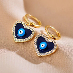Elegante gouden hartvormige oorbellen met blauw emaille oog en sprankelend kristal