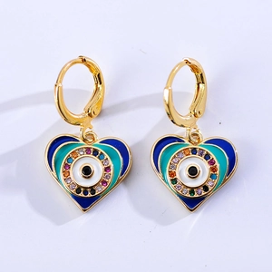 Detail van hartvormige evil eye oorbellen met kleurrijke zirkoon en blauw email in goud