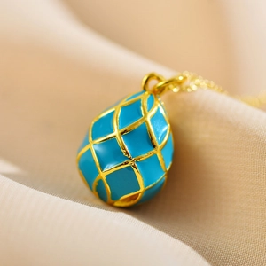 Detailed view of water drop pendant with sky blue enamel and golden lattice mesh finish