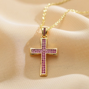 Close-up of gold cross pendant necklace featuring purple micro-pave cubic zirconia stones