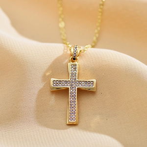 Detailed view of gold cross necklace with micro-set purple cubic zirconia on silk