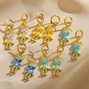 Vue détaillée des boucles d'oreilles ours en émail coloré avec zircons sur tissu