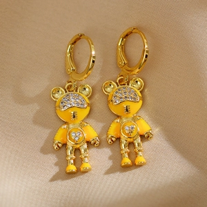 Détail de boucles d'oreilles ours astronaute en émail jaune avec pavé de zircons