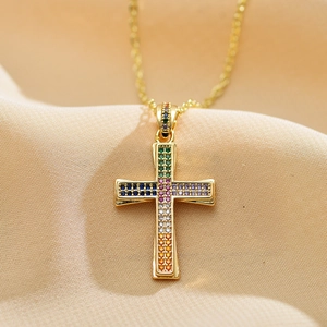 Detailed close-up of a gold cross pendant with vibrant multi-color rainbow cubic zirconia