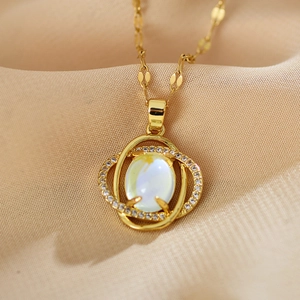 Elegante goldene Kleeblatt-Halskette mit Katzenaugenstein und Zirkonia auf Seidenstoff