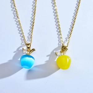 Détail du pendentif pomme en opale avec feuille en zircon sur chaîne dorée