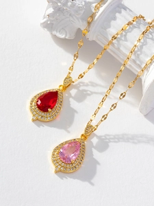 Close-up of luxury water-drop pendants with red and pink stones and gold chains