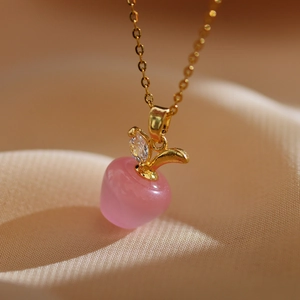 Détail du pendentif pomme en pierre oeil-de-chat rose avec chaîne dorée et zircon