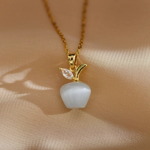 Vue macro du pendentif pomme doré avec pierre oeil de chat et feuille en zircone cubique