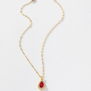 Elegant gold necklace featuring a teardrop red gemstone pendant with crystal halo