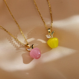 Vue macro de pendentifs pomme en opale rose et jaune avec feuille dorée élégante