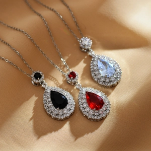 Pear cut halo pendant necklaces with ruby and emerald stones on silver titanium steel