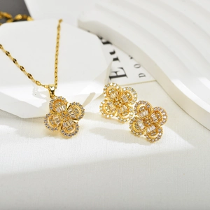 Detailweergave van gouden klaver sieradenset met ketting en oorbellen met witte zirkoon