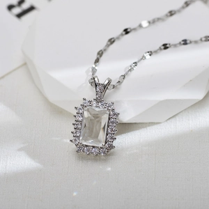Macro shot of silver pendant with rectangular zircon center and pavé diamond halo