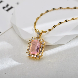 Close-up of golden necklace with a rectangular pink gemstone and zircon halo detail