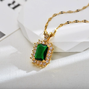 Detailed close-up of emerald-cut green zircon necklace with gold plating and halo diamonds
