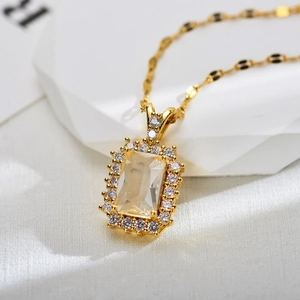 Macro shot of rectangular clear zircon necklace with halo setting and gold link chain