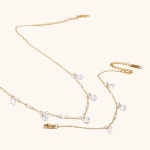 Detail of 18K gold plated stainless steel necklace with clear zircon charms and S.steel tag