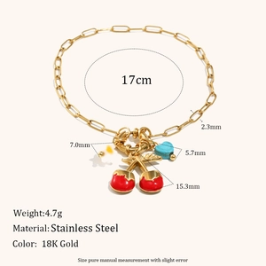 Detail of 18K gold-plated stainless steel bracelet with red cherry and blue heart charms