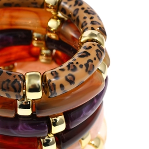 Close-up of leopard print and amber resin beads with gold spacers on a layered bracelet