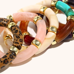 Macro detail of acrylic bamboo bangle bracelets with leopard print and gold metal spacers
