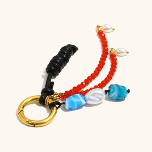 Detail of 18K gold-plated spring clasp with red glass beads and black leather cord