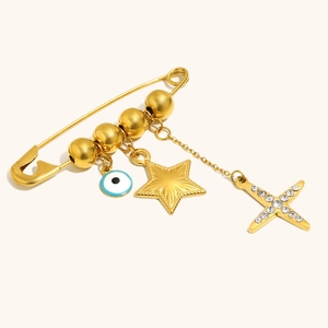 Gold-plated safety pin brooch with evil eye charm, star pendant, and crystal cross
