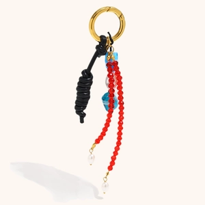 18K gold plated stainless steel keychain with black leather cord and red beaded tassels