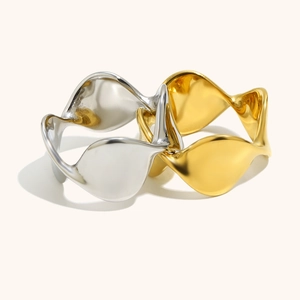 Dettaglio di anelli ondulati minimalisti in oro 18K e argento con finitura lucida