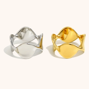 Dettaglio di anelli geometrici a onda intrecciati in argento lucido e oro 18 carati