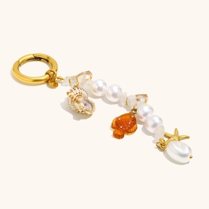 Detail of 18K gold starfish and seashell keychain with pearls and crystals