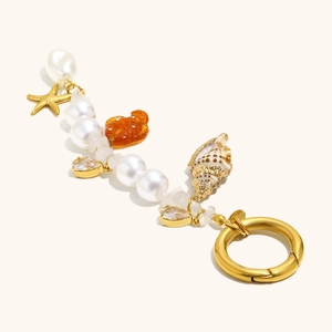Marine charm keychain with pearls, starfish, and conch on gold-plated spring ring